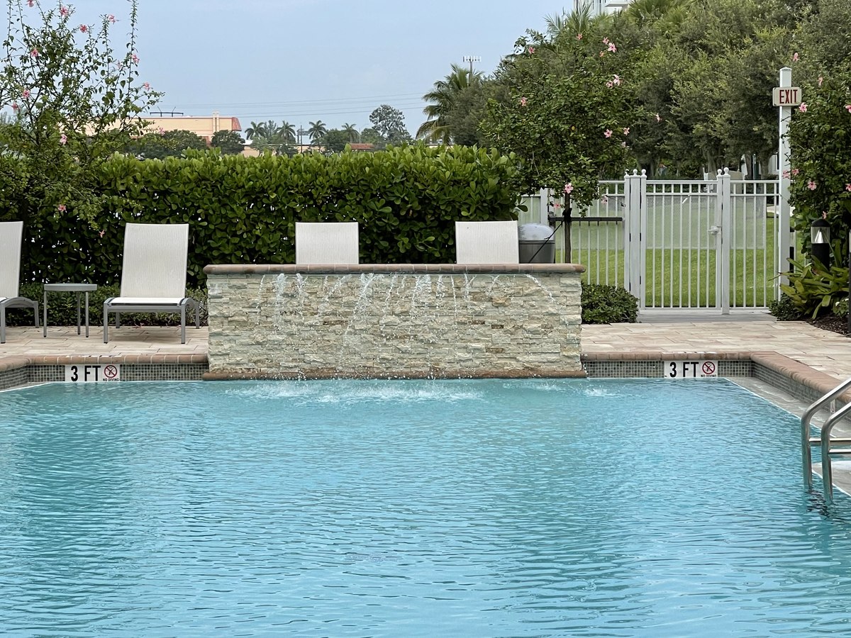 Sliding-glass-door track set into a finished condo unit overlooking palms and a Mediterranean building beyond.